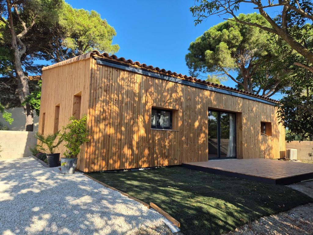 une petite maison avec une façade en bois dans l'établissement Le Gîte du Parc, à Roubia