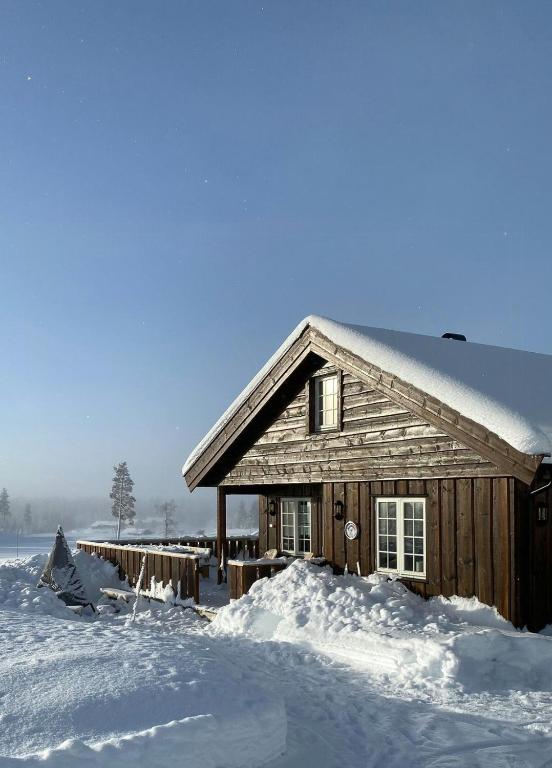 a wooden house covered in snow with a lot of snow at Family Cabin With Ski Inout At Furutangen in Vika