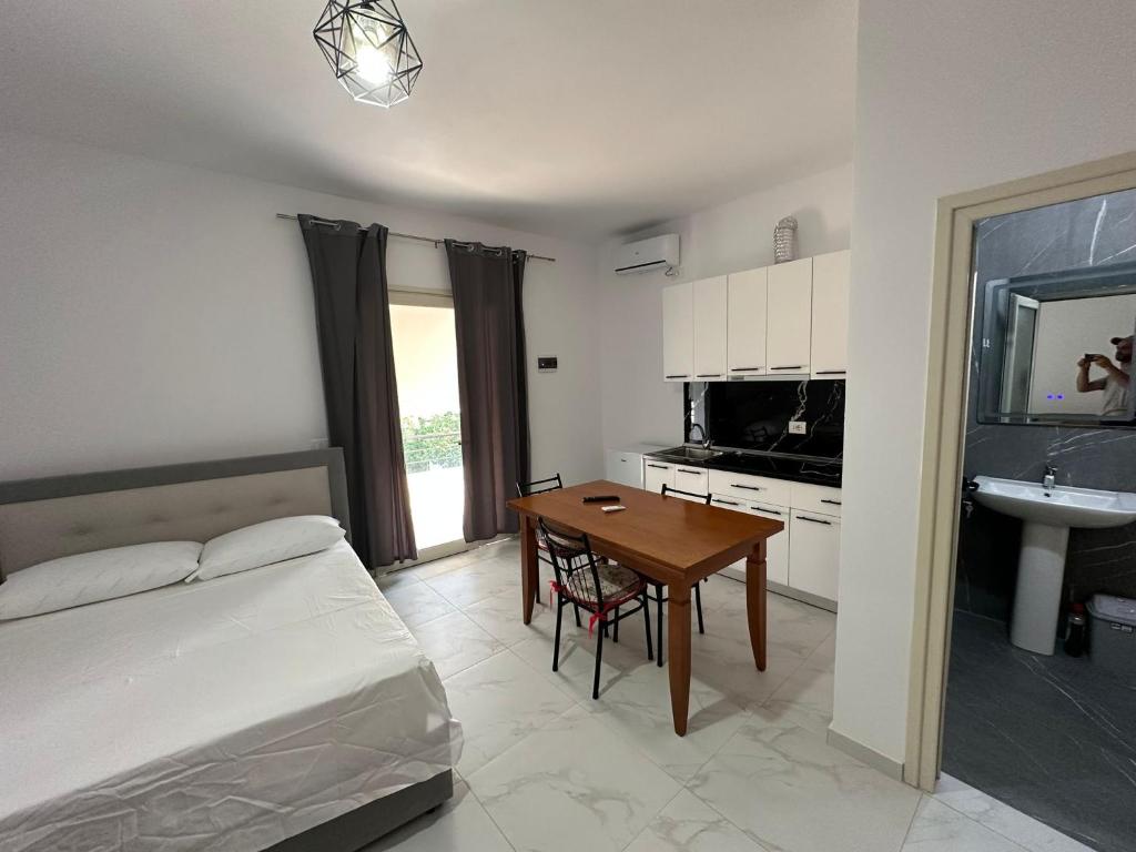 a bedroom with a bed and a table and a sink at Villa Aliaj in Vlorë