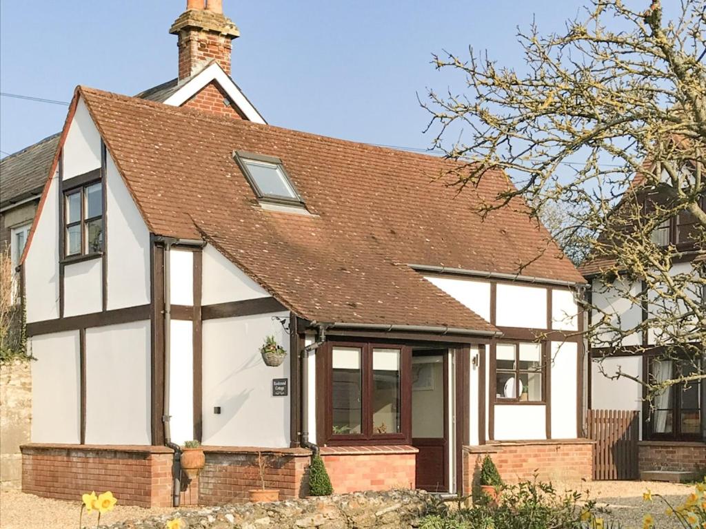 a white and red house with a brown roof at Rookmead Cottage in Yarmouth
