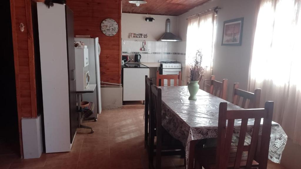 a kitchen with a table with chairs and a refrigerator at Cabaña Sol&Luna in Tafí del Valle