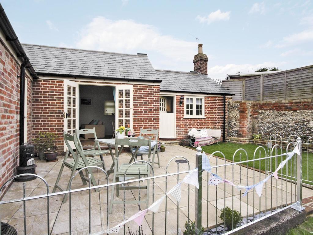 a patio with chairs and a table in a yard at Shrimp Cottage - E5415 in Kessingland