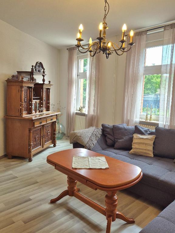 a living room with a blue couch and a table at Ferienhaus Bärbel Großes Ferienhaus nahe Quedlinburg in Ditfurt