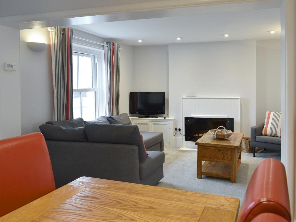 ein Wohnzimmer mit Sofa und Fernseher in der Unterkunft Coastguard Cottage in Ryde