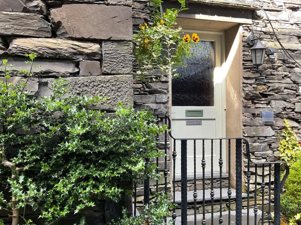 a door of a stone building with a pay phone at Shambles Cottage in Ambleside