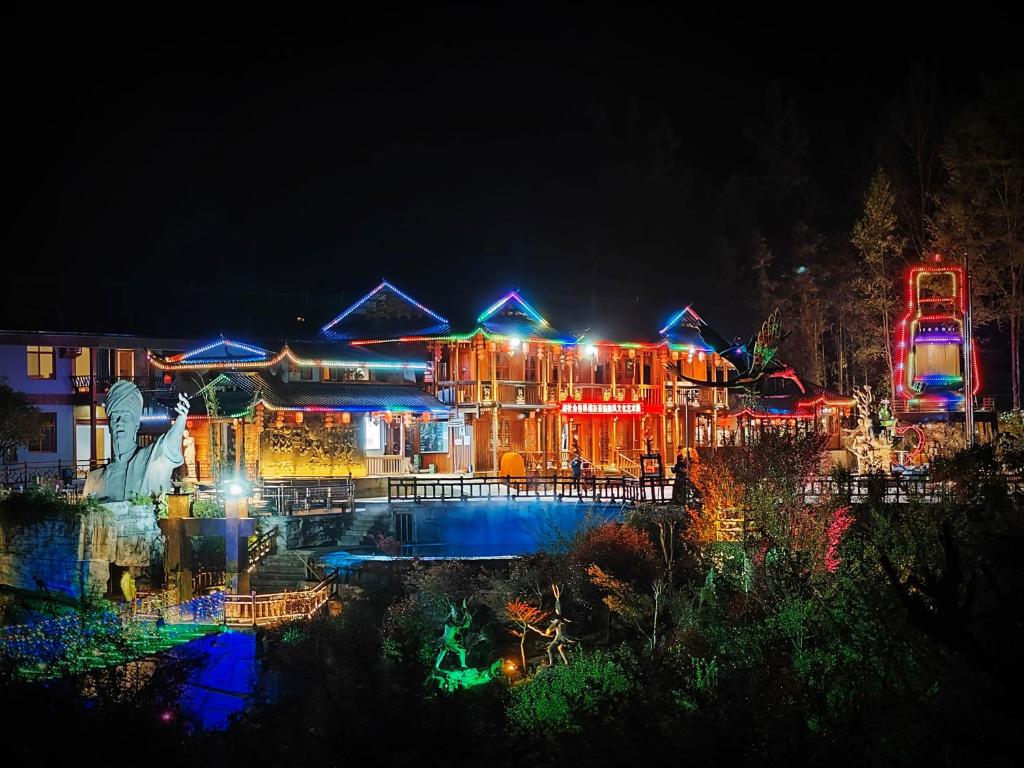 a house lit up at night with lights at 张家界熊风艺术园森林有约民宿 in Zhangjiajie