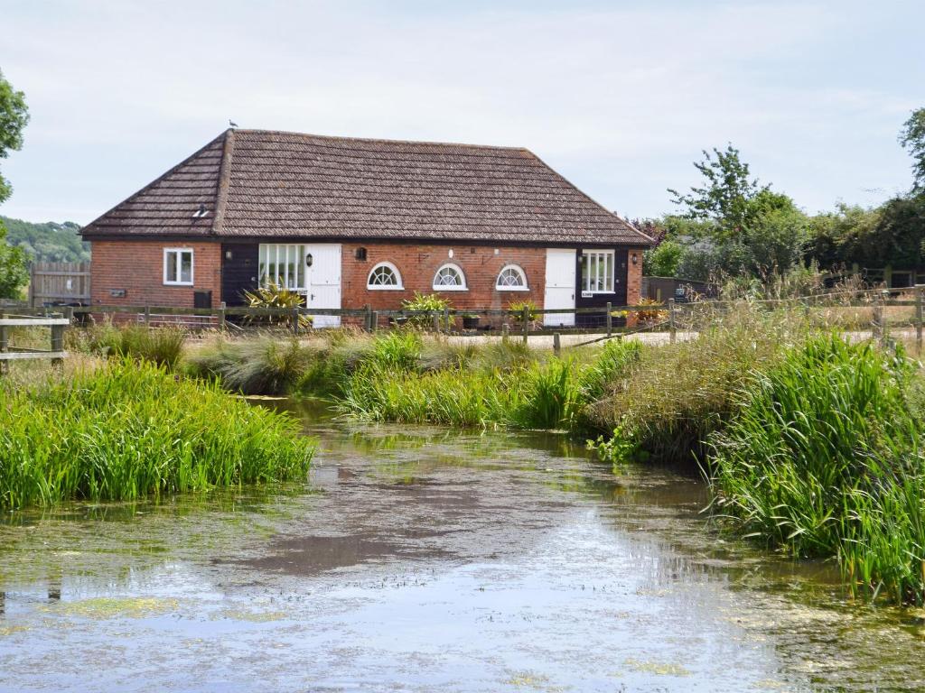 une maison avec une rivière devant elle dans l'établissement Blenheim Cottage-19652, à Peasmarsh