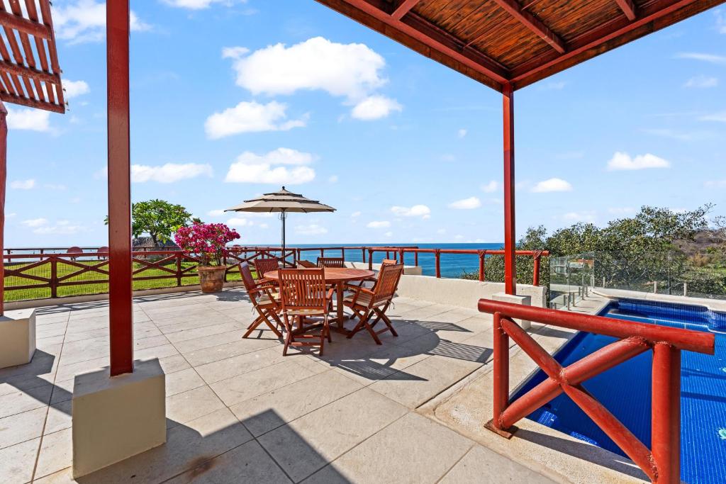 a patio with a table and chairs and a swimming pool at Villa Alhelí | Ocean View 3BR w/ Private Pool, Steps to Beach – Sayulita in Sayulita