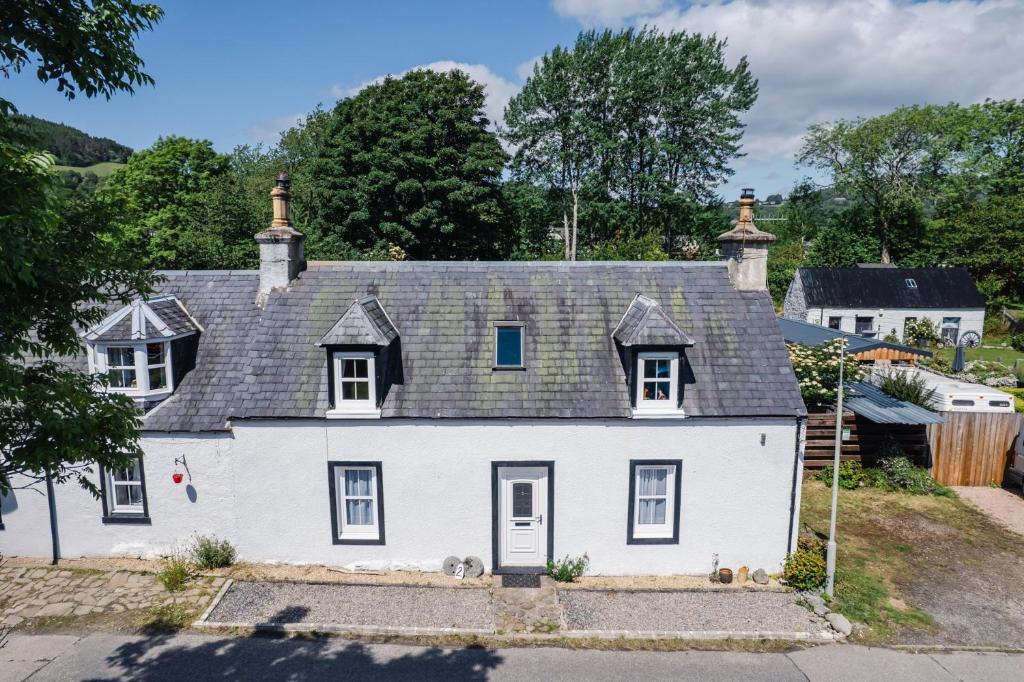 a white house with a gray roof at Traditional Highland Cottage Near Loch Ness in Drumnadrochit