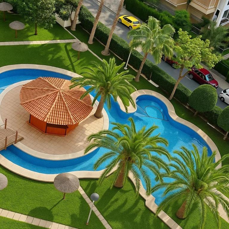 an overhead view of a swimming pool with palm trees and an umbrella at Ola Azul Bungalow in Benidorm
