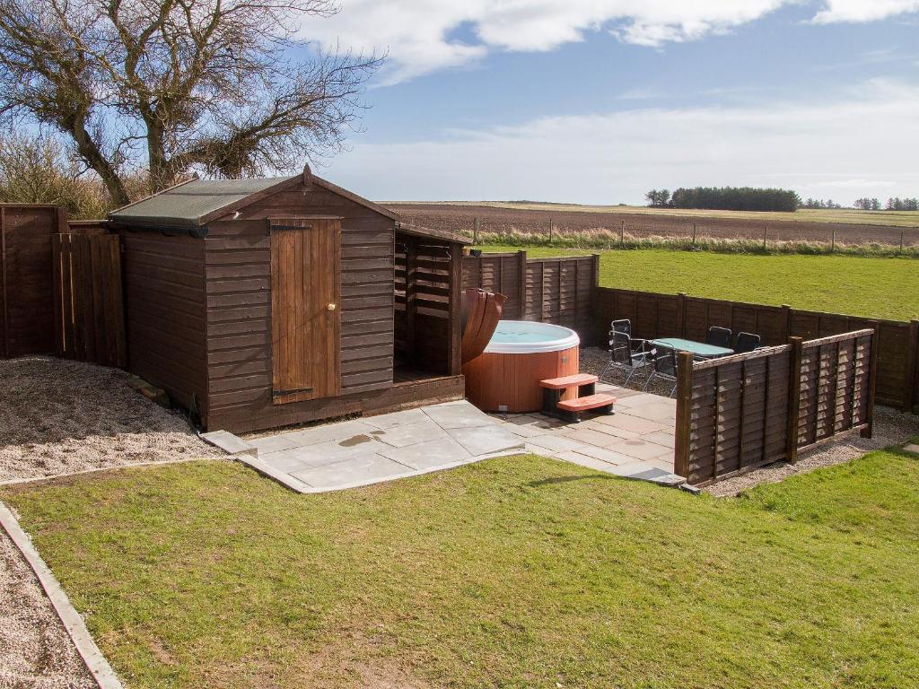 a small wooden shed with a bench and a table at Sheaf Dale in Portmahomack