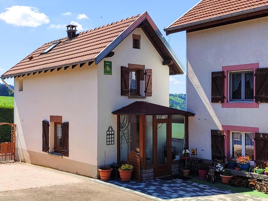 une grande maison blanche avec une grande porte dans l'établissement Gîte rustique à Laveline-du-Houx, proche forêt - FR-1-589-141, à Laveline-du-Houx