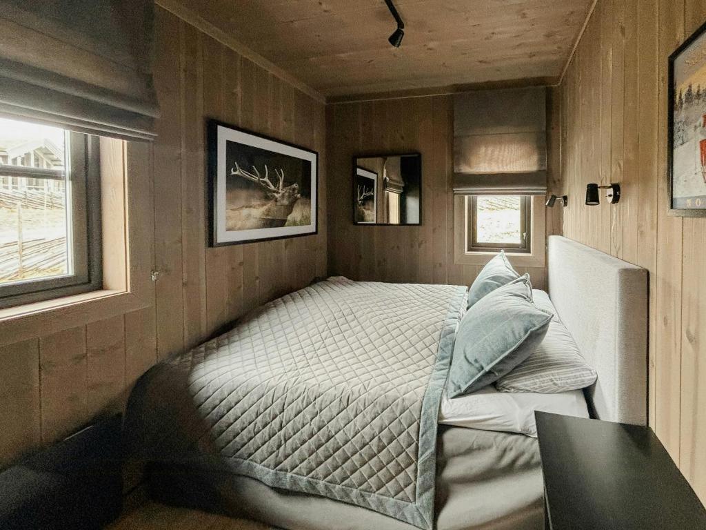 a bedroom with a bed in the corner of a room at Modern Cabin By Skeikampen's Ski Trails in Svingvoll