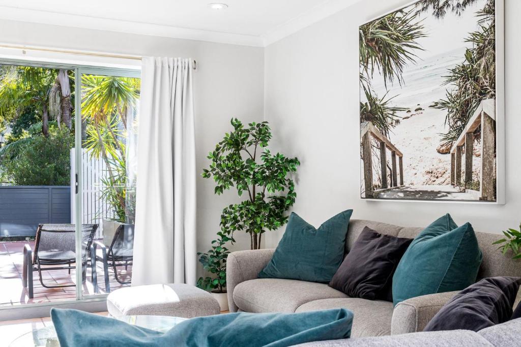 a living room with a couch and a view of the beach at Byron Beachside 2 in Byron Bay