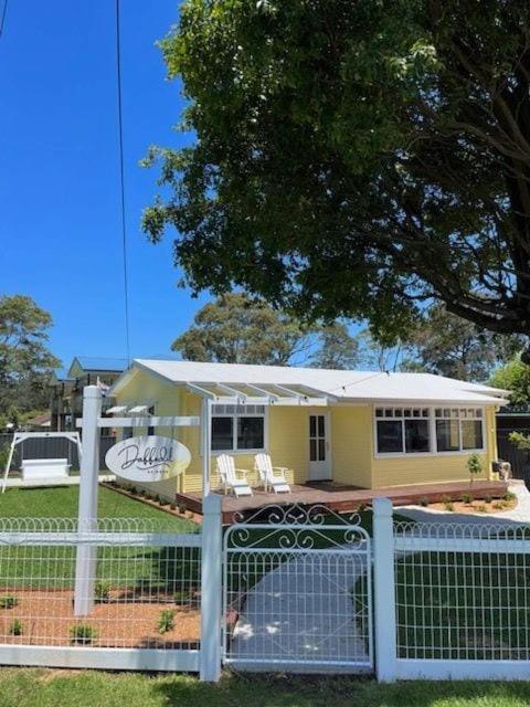 a small yellow house behind a fence at Daffodil on Owen in Huskisson