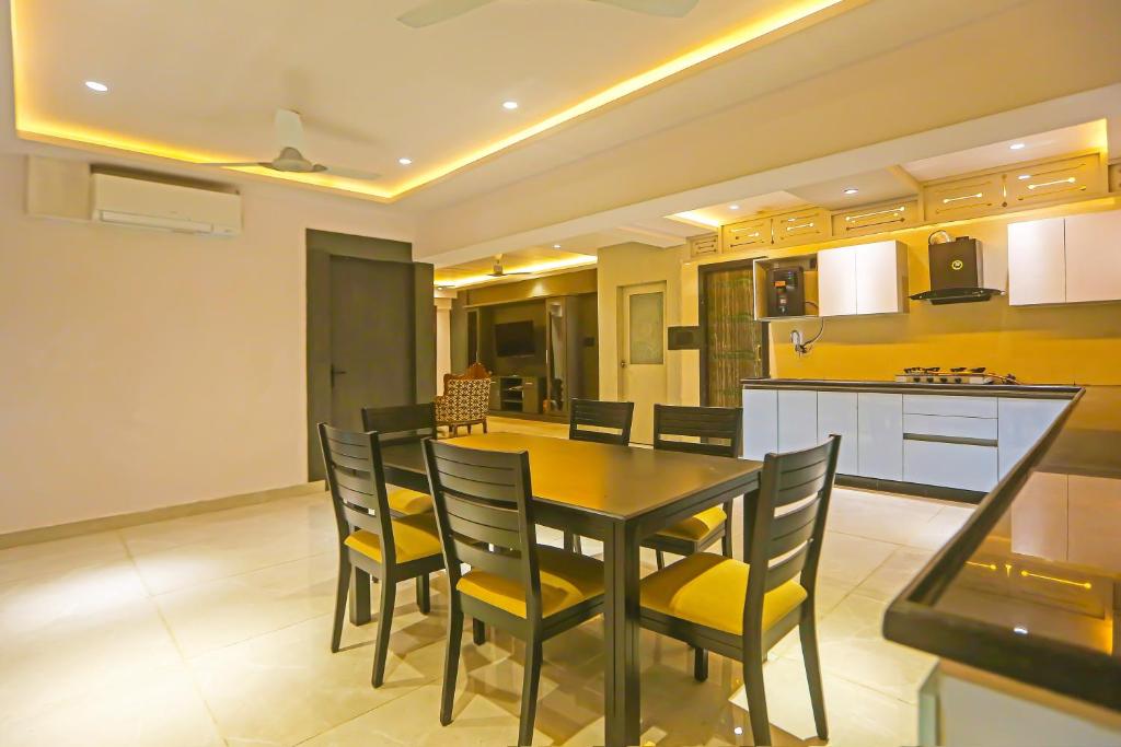 a kitchen and dining room with a table and chairs at Super Hotel O Botcha Convection in Visakhapatnam