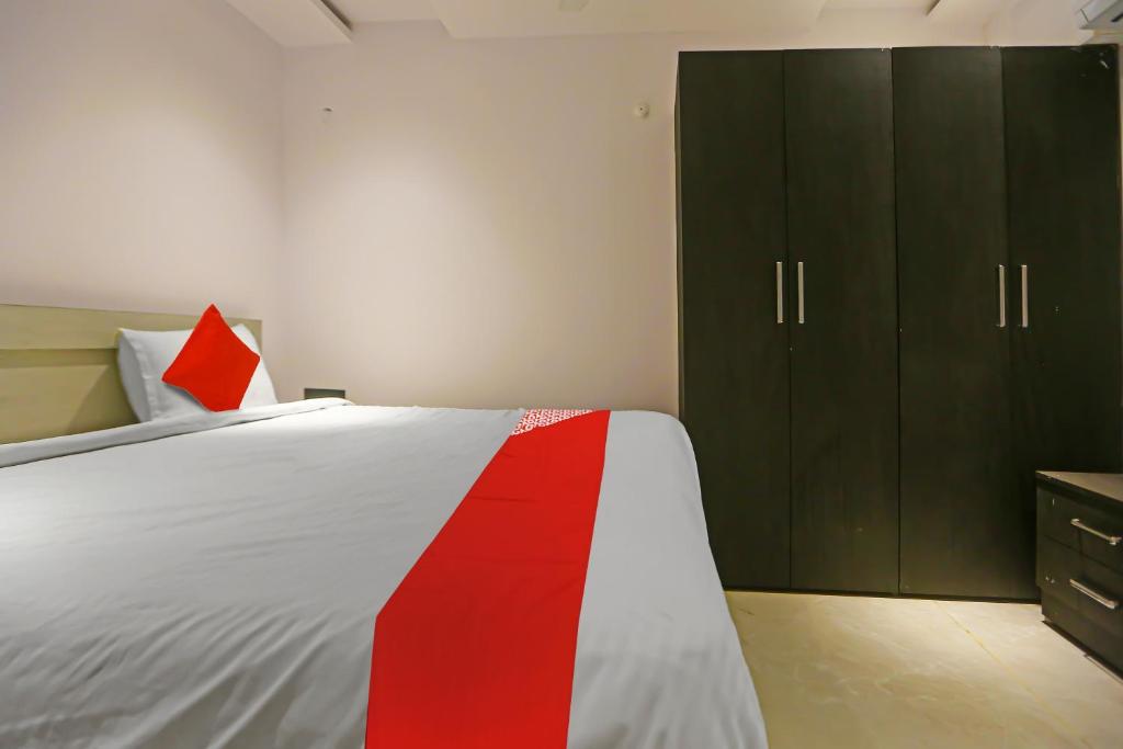 a bedroom with a bed with a red stripe on it at Super Hotel O Botcha Convection in Visakhapatnam