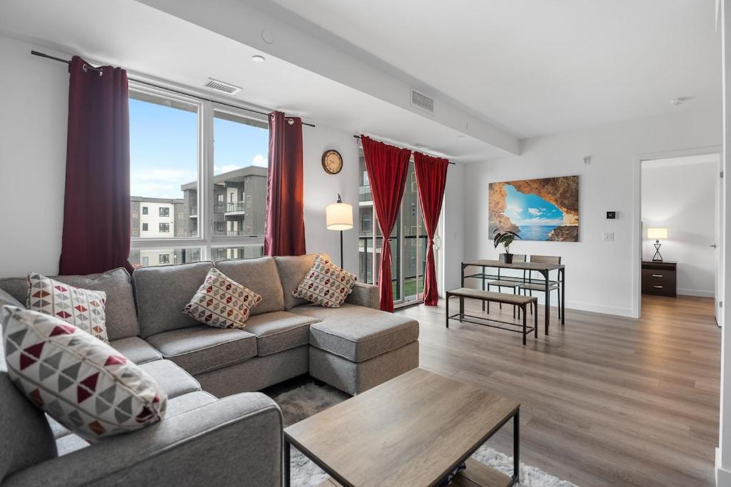 una sala de estar con un sofá y una mesa en Peaceful 2BR Retreat with parking Situated 7 Mins to the Falls, en Niagara Falls