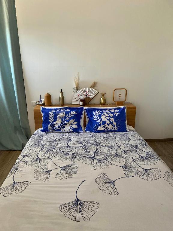 - un lit avec des draps bleus et blancs et des oreillers bleus dans l'établissement Peaceful Family Retreat In Aix-En-Provence, à Puyricard