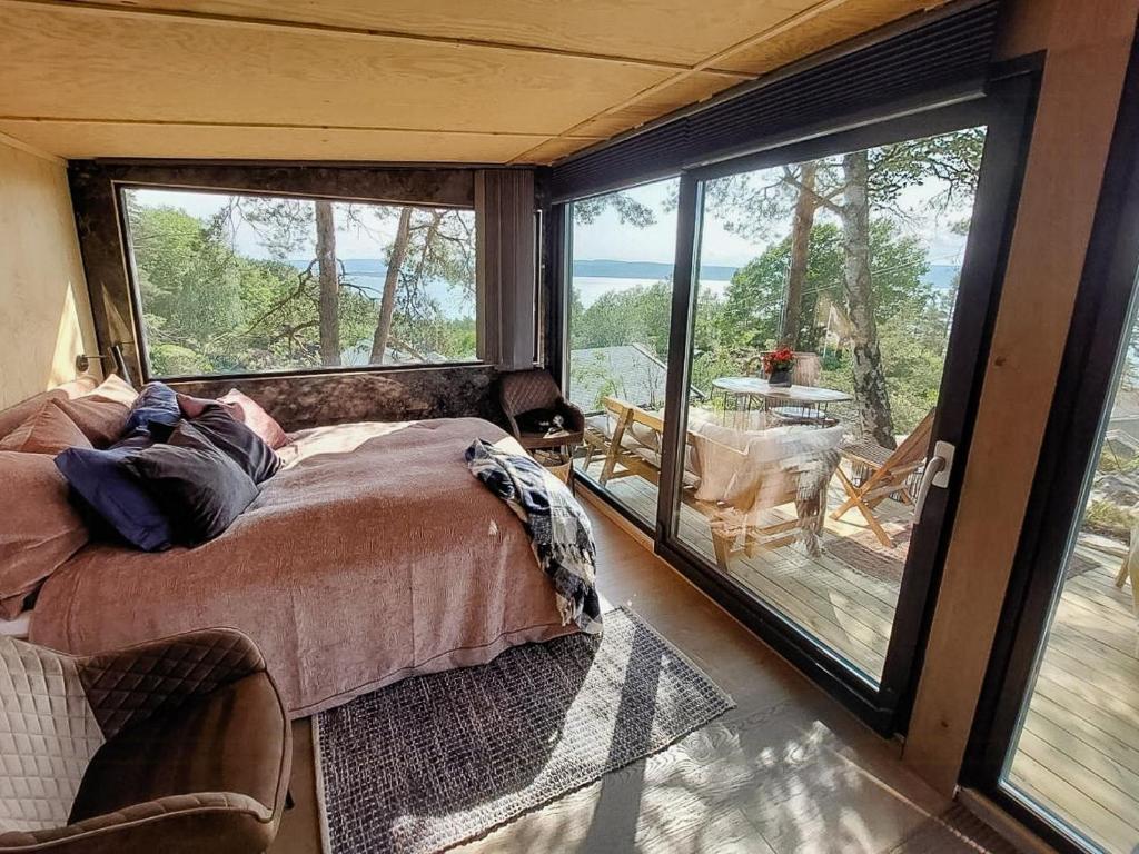 a bedroom with a bed and a balcony with a view at Unique Design And Beautiful View In Fjellstrand in Fjellstrand