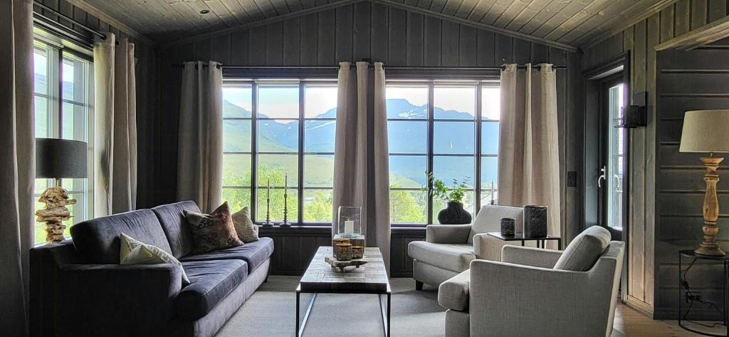 a living room with two couches and a large window at Modern Cabin With Ski In-Out In Great Area in Brunstad