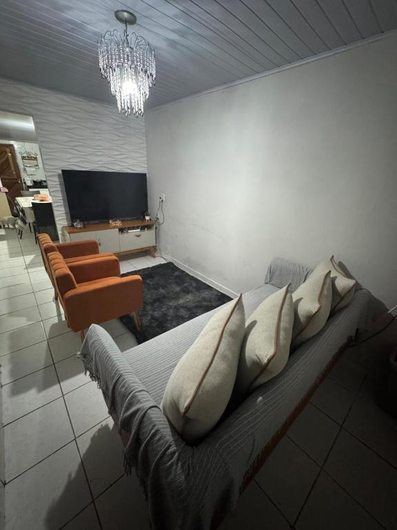 a bedroom with a bed with pillows and a television at Casa para temporada Garanhuns - Natal Luz, Festival do vinho, Festival de inverno, Viva dominguinhos in Garanhuns