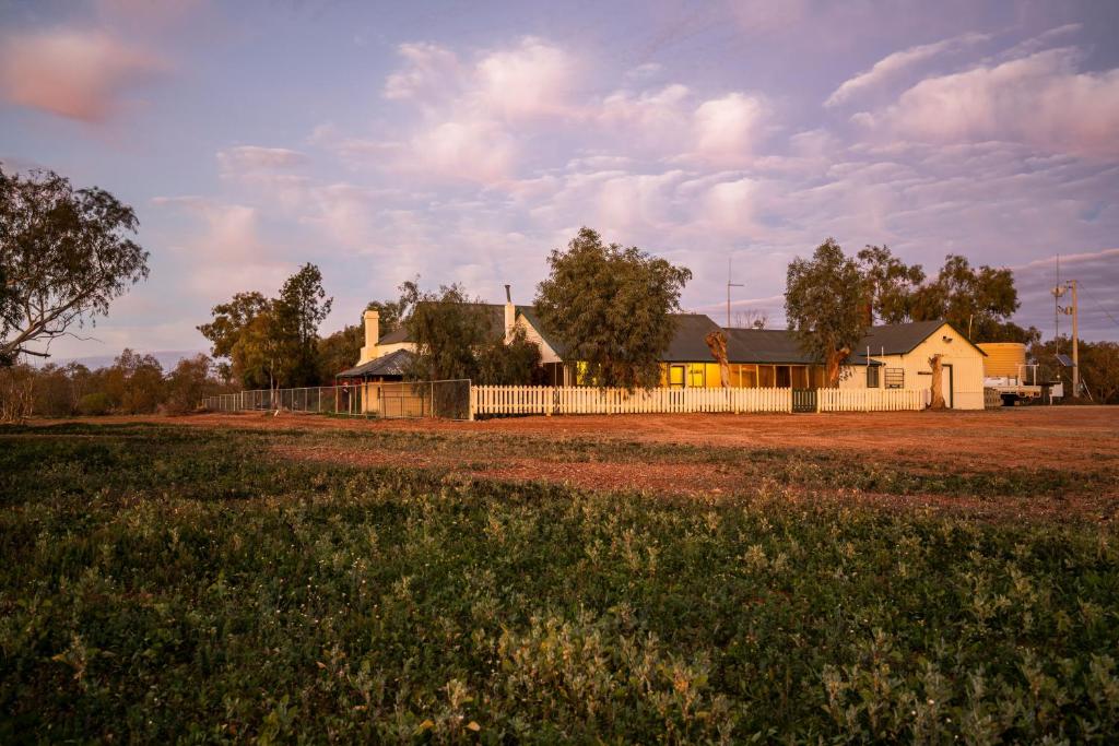 ein Haus mit einem Zaun vor einem Feld in der Unterkunft Mount Wood Homestead 