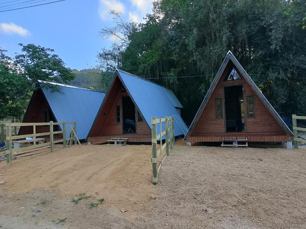 una piccola casa con il tetto blu nella terra di Pousada Vale das Pedras 03 a Pedras Grandes