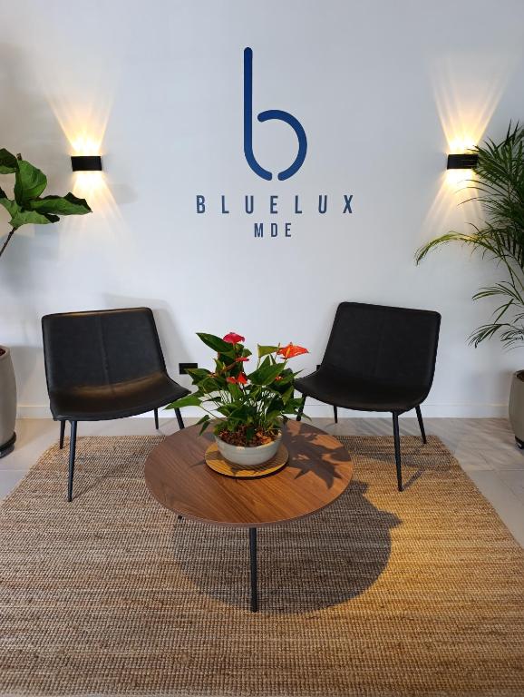 two black chairs and a table with a plant on it at Bluelux Med - B&B in Medellín