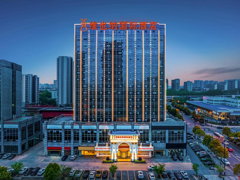 长沙Vienna International Hotel Changsha BBK Meixi Xintiandi Branch的一座高楼,在城市里,有停车位