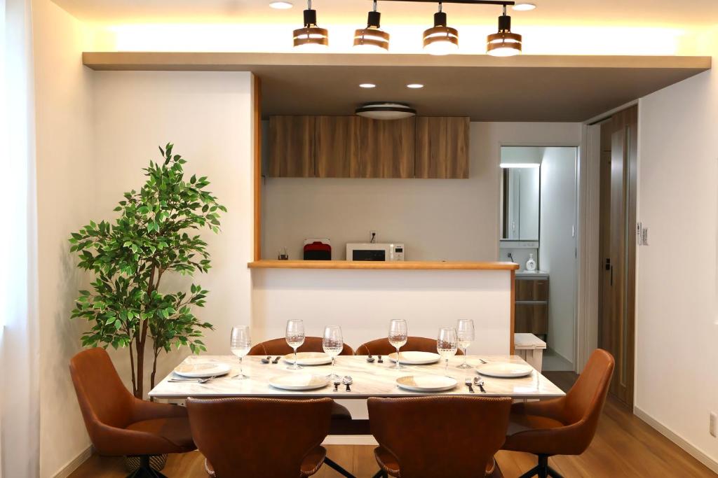 een eetkamer met een tafel met wijnglazen bij New open 岸里玉出 Maison Le Jaune 玉子心斋桥道顿崛电车直达 in Osaka