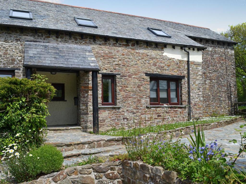 una casa in mattoni con finestre e un vialetto in pietra di Willow Cottage a Woolfardisworthy