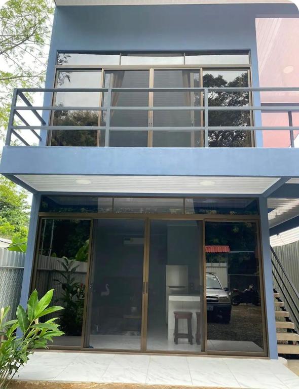 a blue house with sliding glass doors and a table at Apartamentos zafiro in Bahia