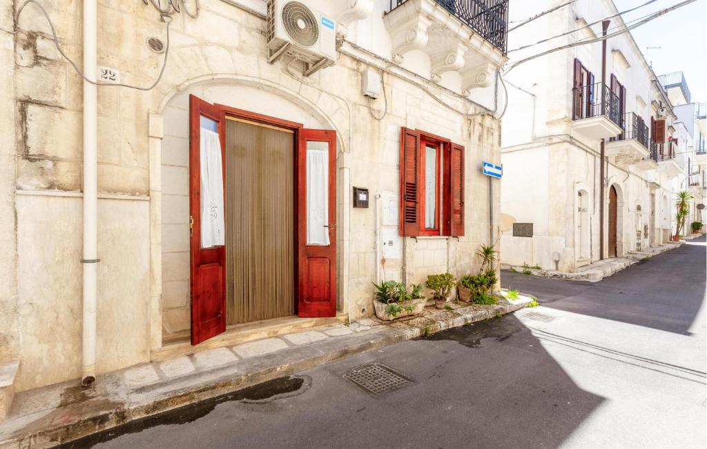 un edificio antiguo con puertas rojas en una calle en Appartamento Nonna Rosa, en Ostuni