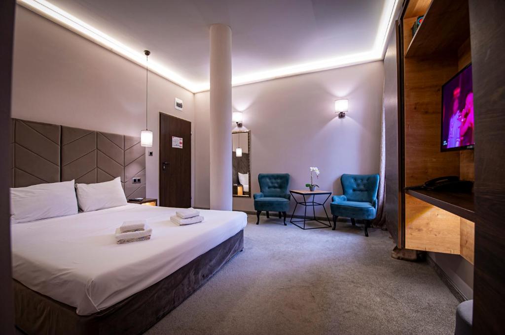 a hotel room with a bed and two chairs at Вила АРБОРЕТУМ in Teteven