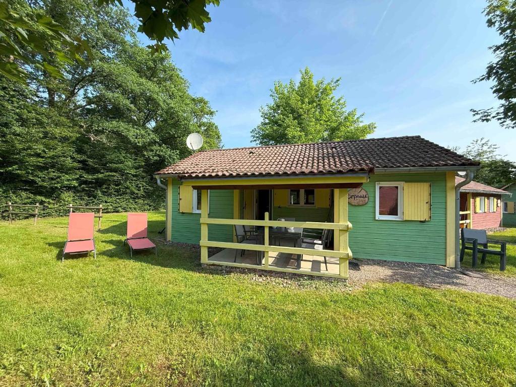 a small green house with two chairs in the yard at Chalet paisible pour 6 personnes au cœur de la nature - FR-1-583-419 in Mélisey