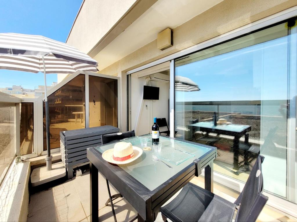 d'une table à manger et de chaises sur un balcon avec vue. dans l'établissement Studio moderne climatisé, 2 pers, face à la mer, proche plage et commerces, Canet-en-Roussillon - FR-1-794-133, à Canet