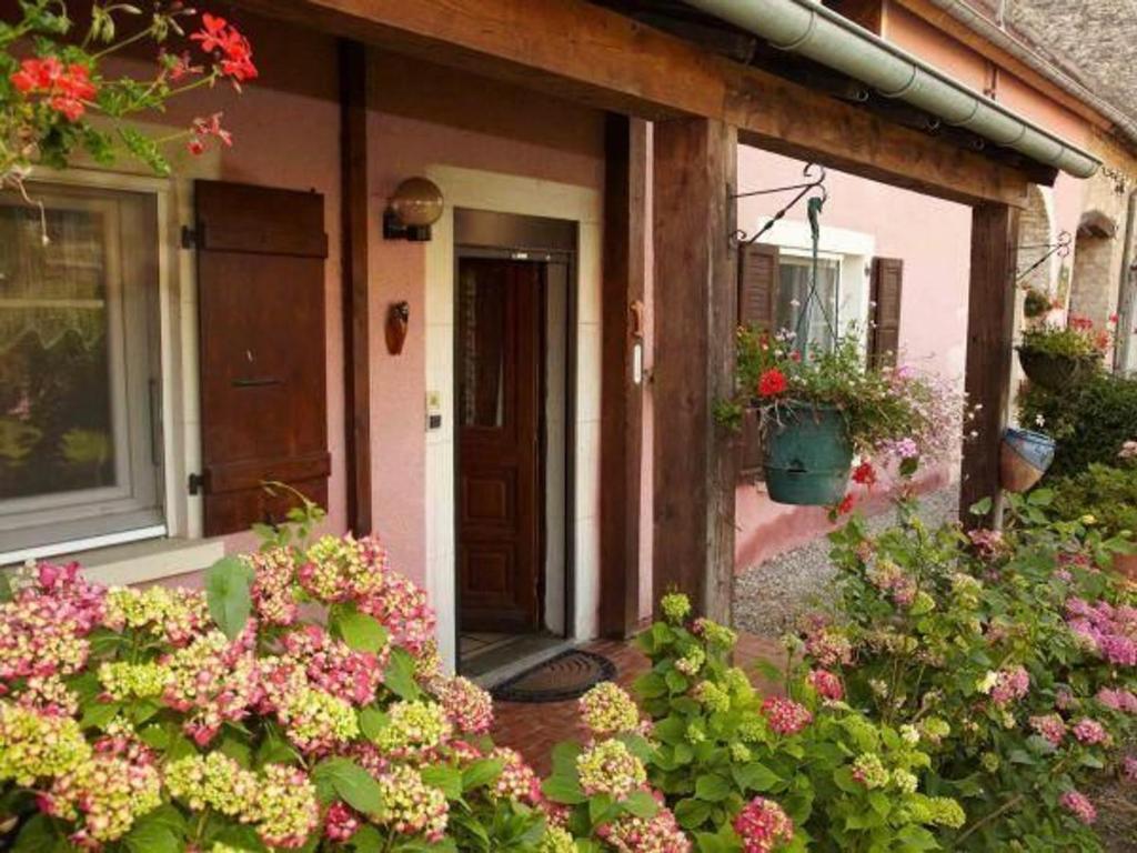 une porte d'entrée d'une maison fleurie dans l'établissement Maison familiale à Brotte-lès-Ray, lits faits à l'arrivée - FR-1-583-427, à Brotte-lès-Ray