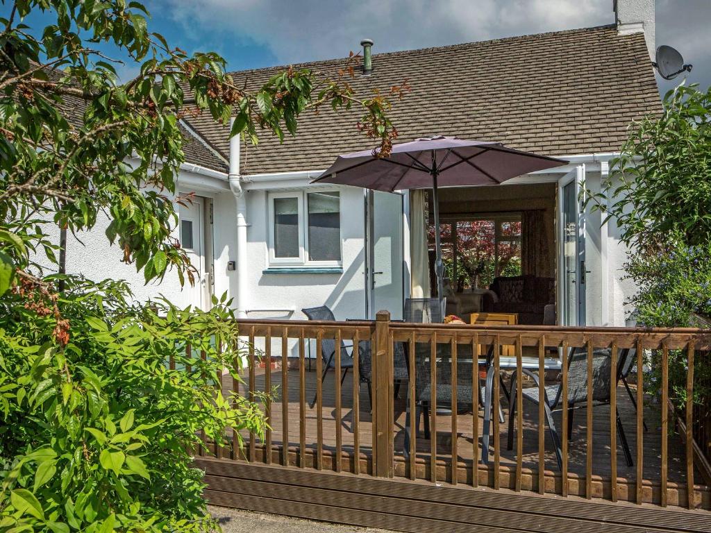 a house with a wooden deck with an umbrella at Briargarth in Keswick