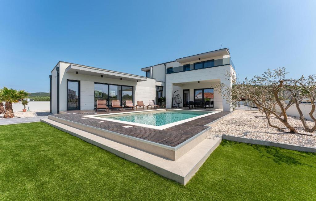 a house with a swimming pool in the yard at Cozy Home In Turanj With Sauna in Turanj