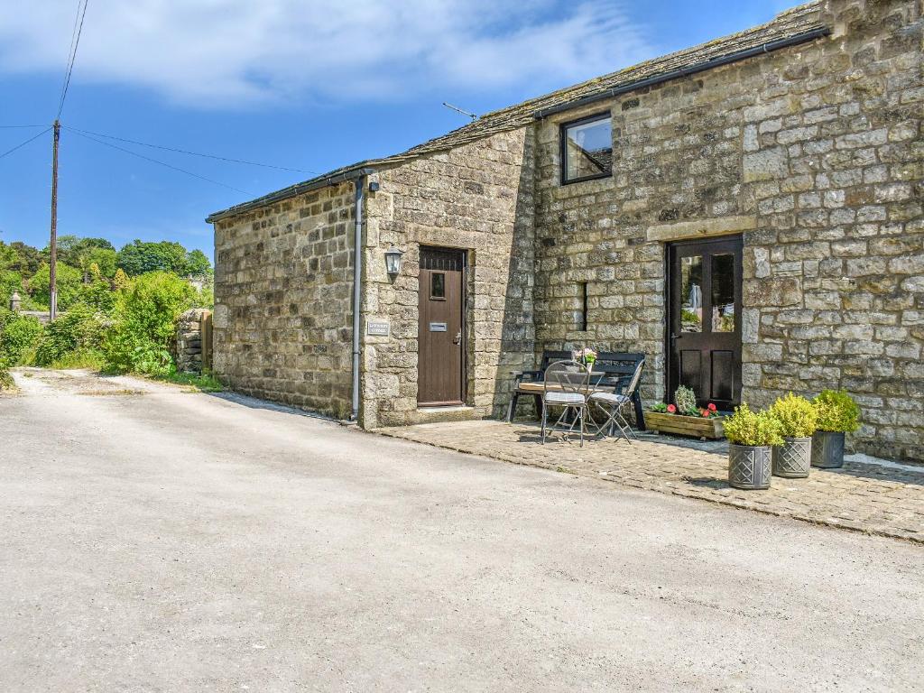 a stone building with a table outside of it at Ladycroft Cottage in Hebden
