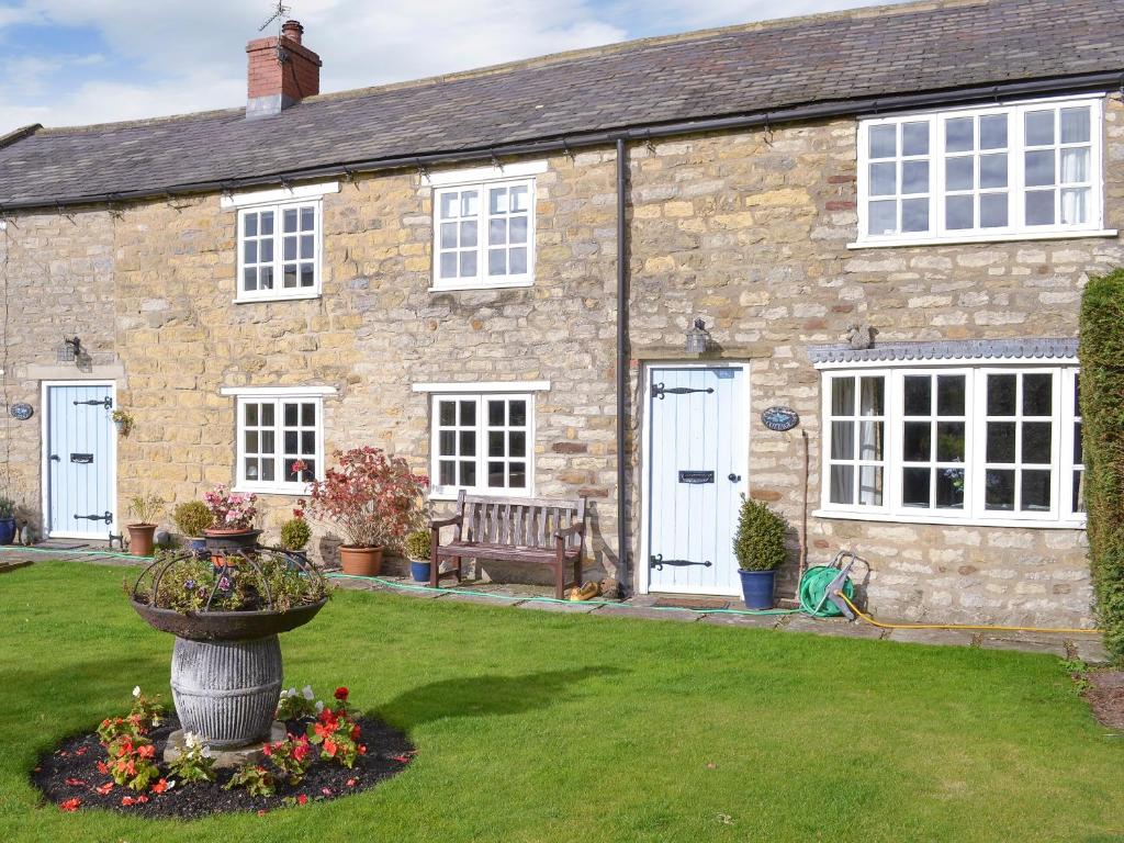 a stone house with a bench in front of it at Lilac Cottage in Sinnington