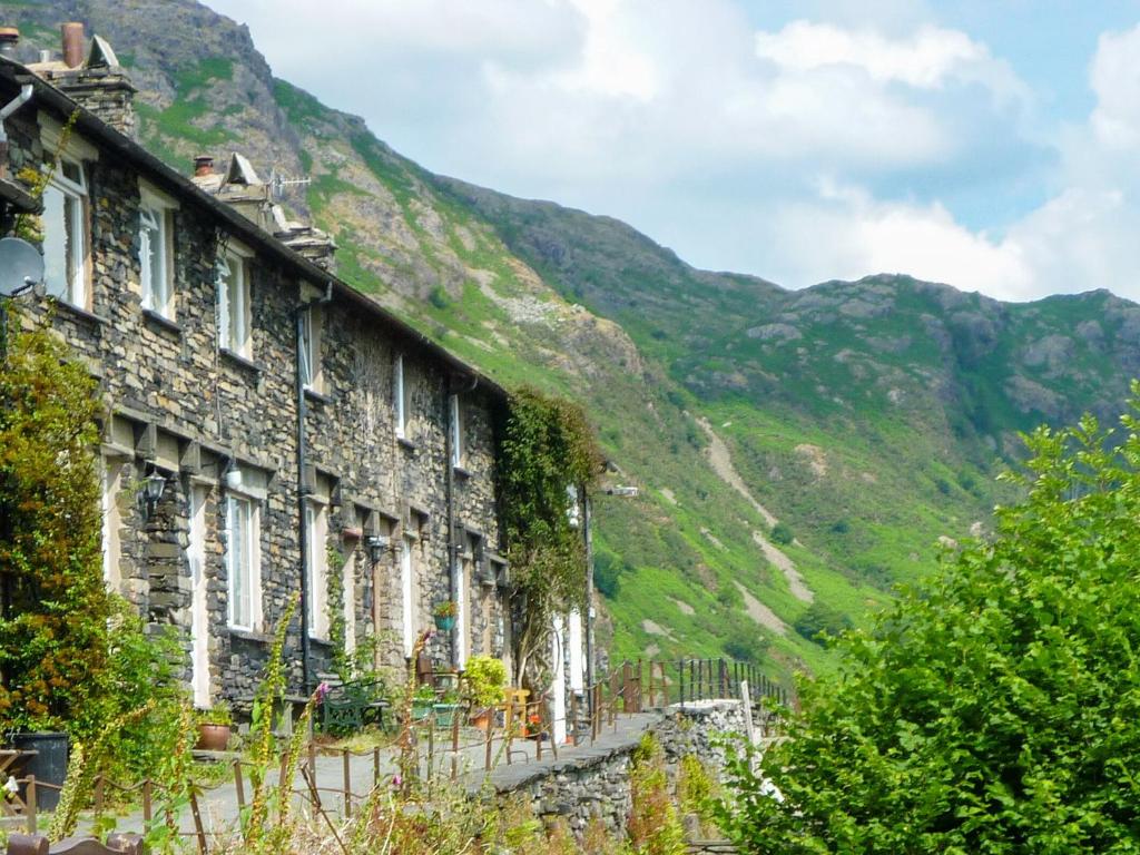 een rij stenen huizen met bergen op de achtergrond bij Thurston View in Coniston