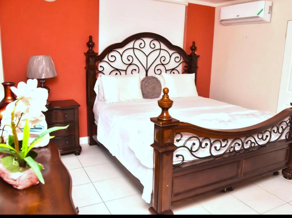 - une chambre avec un lit aux murs orange dans l'établissement Royal Exquisite Deluxe, à Kingston