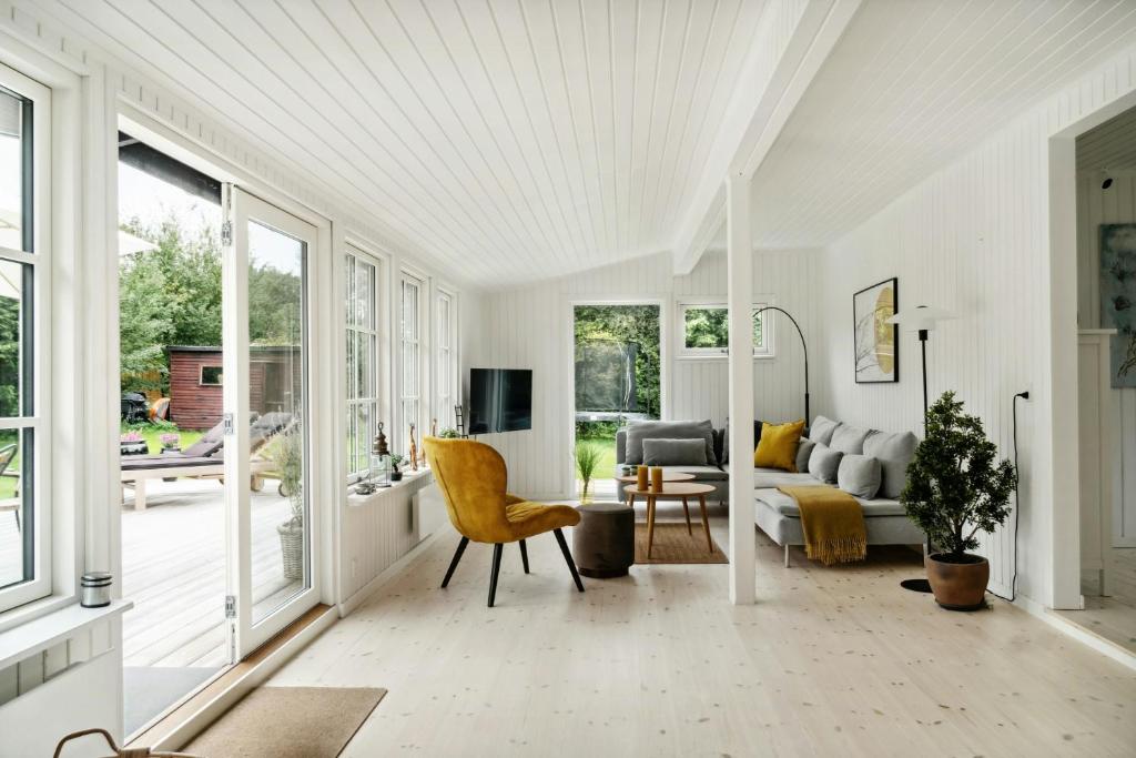 a living room with a couch and a table at Bright And Classic House Near Høve Beach in Asnæs