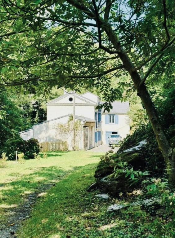 une maison blanche au milieu d'une cour dans l'établissement Historic Mill In The Heart Of Black Mountain, à Caudebronde