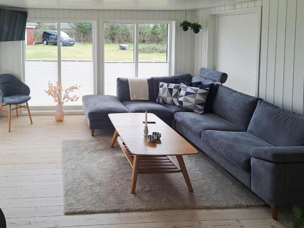 a living room with a blue couch and a coffee table at Cottage Charm Near Lønstrup Lighthouse in Lønstrup