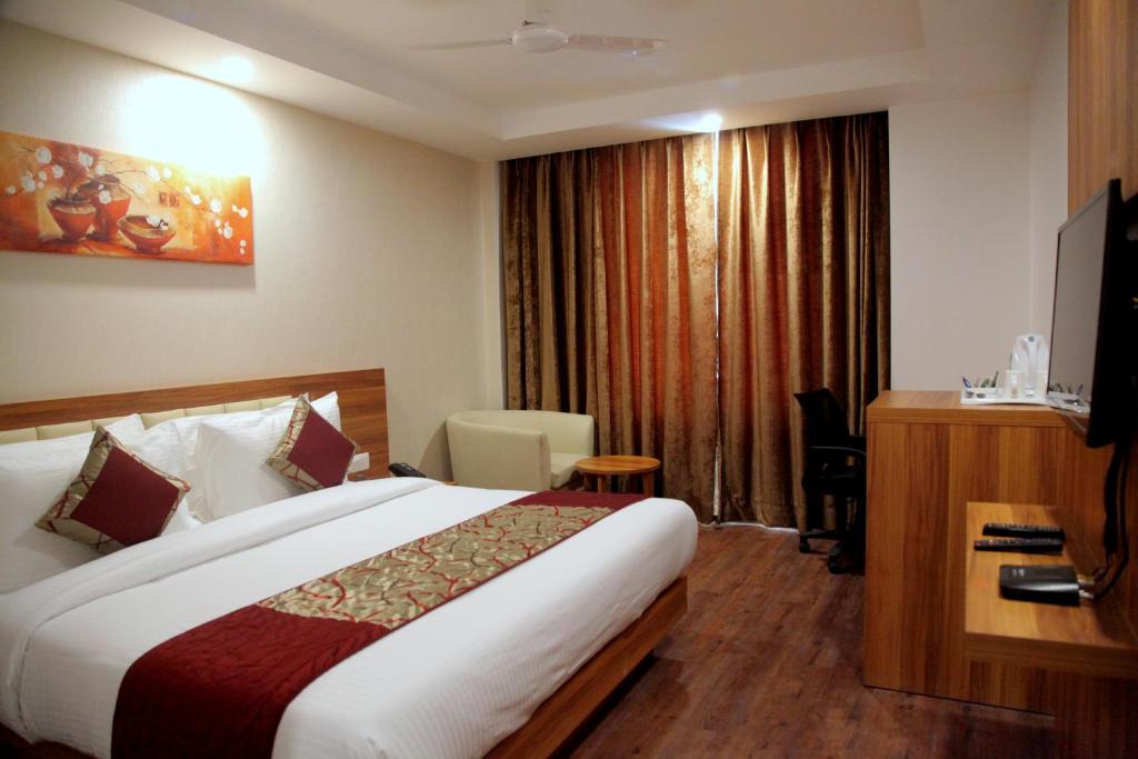 a hotel room with a bed and a desk at Le Roi Jammu - Near Jammu Railway Station in Jammu