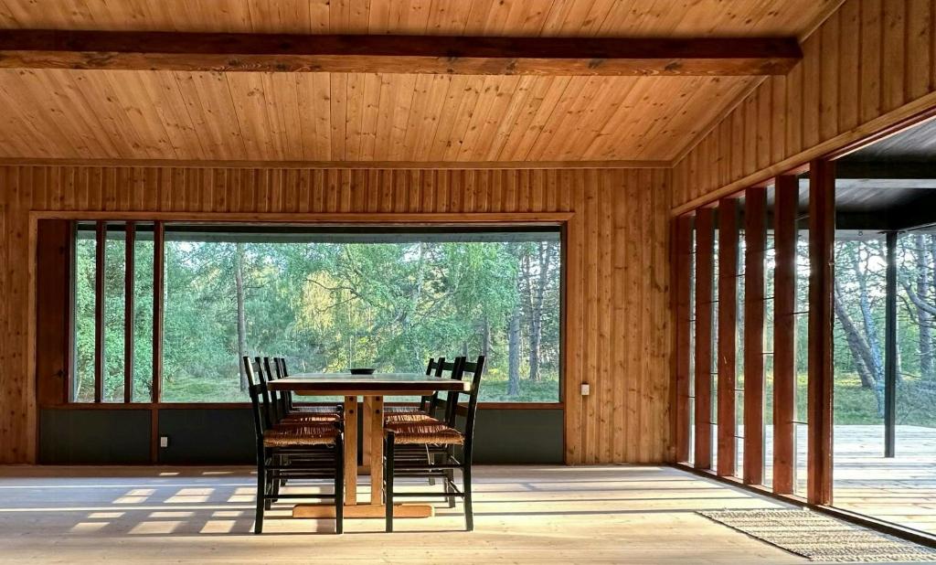 a wooden dining room with a table and chairs at Architectural Holiday Home By Sejerø Bay in Nykøbing Sjælland