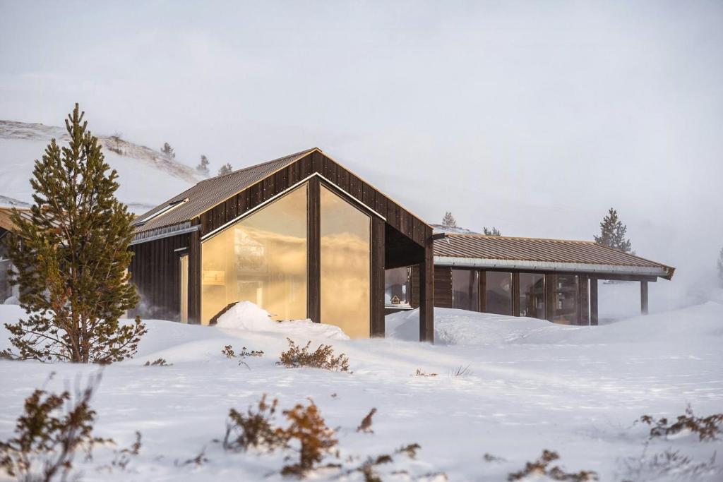 a house in the snow with a large window at Architect Drawn Holiday Home Near Rondane Park in Høvringen